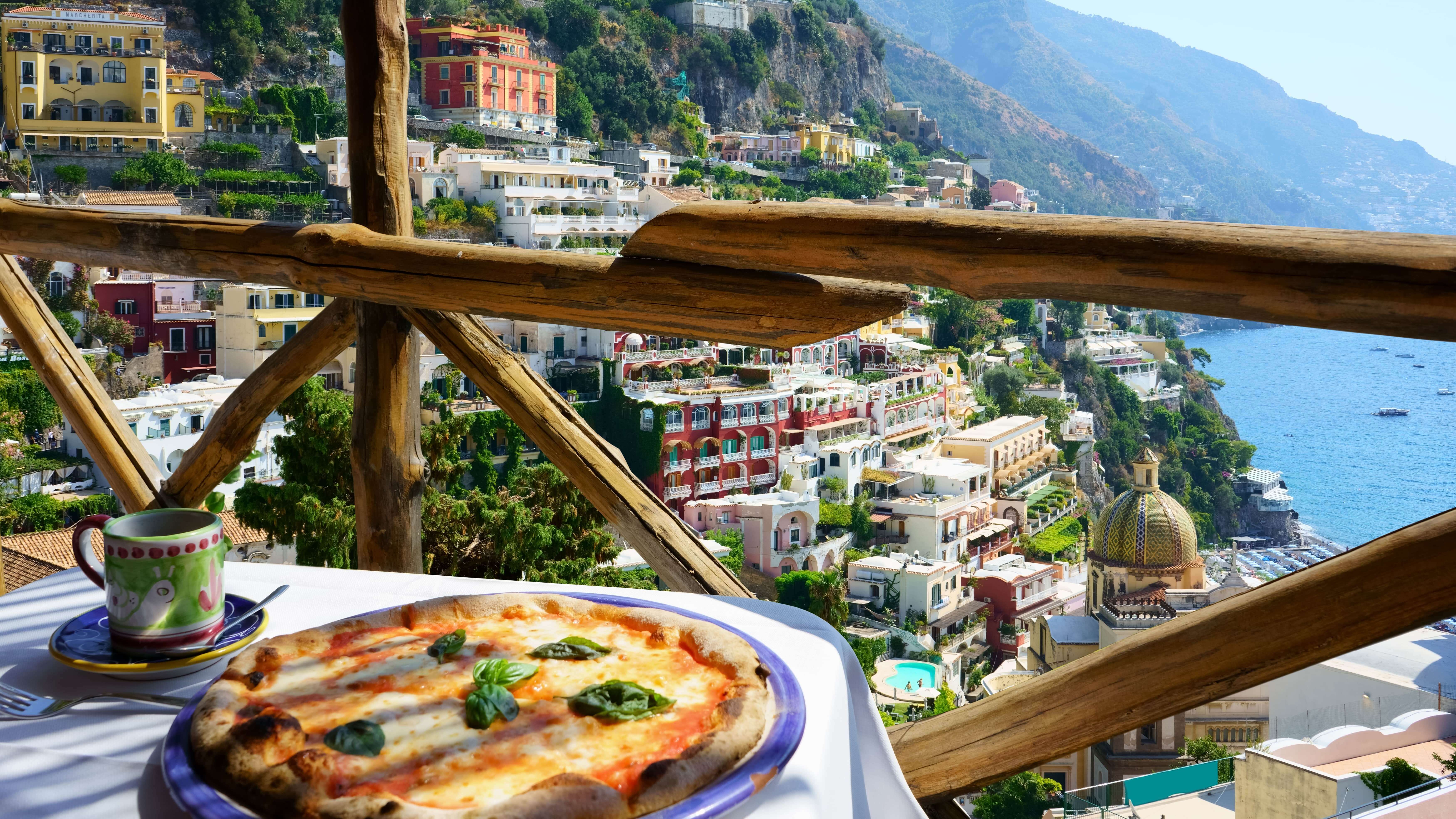 Balcony view. Pizza on a table showing view of gulf of Naples, Italy